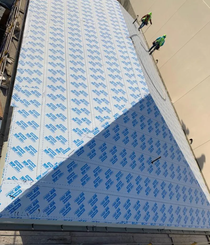 Professional roofers installing underlayment on a metal roof in Norton Shores